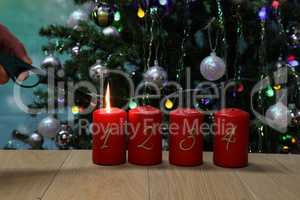 Red Advent candles are lit with a lighter