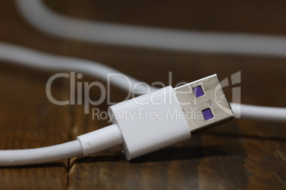USB cable for charging the phone on a blurred background