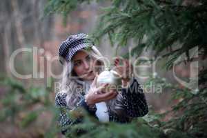 Girl hangs a beautiful Christmas ball on a fir tree