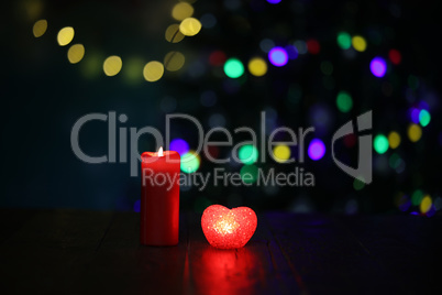 Christmas composition with a burning candle and beautiful bokeh in the background