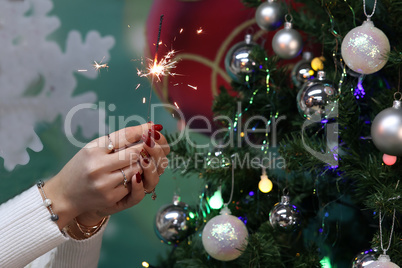 Girl holding a burning sparkler in her hands