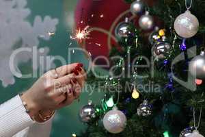 Girl holding a burning sparkler in her hands