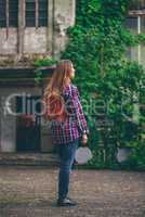 Young woman standing in a front of the old building