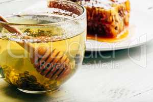 Honey dipper in cup of green tea