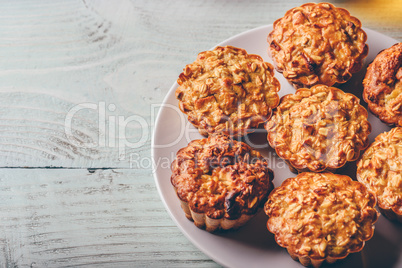 Cooked oatmeal muffins on white plate.