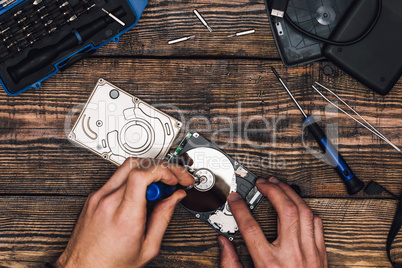 Two Hands with Screwdriver Disassemble HDD