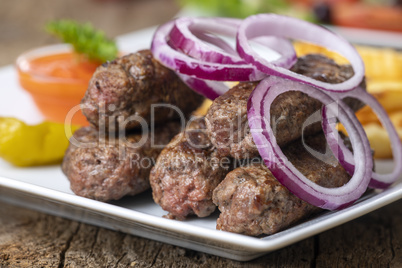 Cevapcici auf einem Teller auf Holz