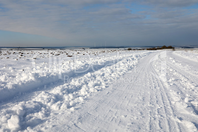 Winter landscape with snowy fields and blue sky