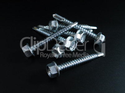 Self-tapping screws galvanized with a semicircular head and a hex head on a black background.