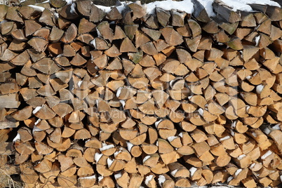 Wood pile of firewood in the forest in winter