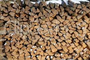 Wood pile of firewood in the forest in winter