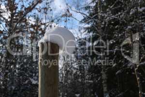 White snow caps on the fence posts