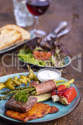 gegrilltes Fleisch und grüner Spargel auf einem blauen Teller