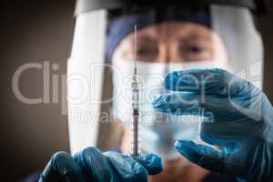 Doctor or Nurse Holding Medical Syringe with Needle AGainst Dark
