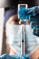 Doctor or Nurse Wearing Surgical Gloves Holding Vaccine Vial and