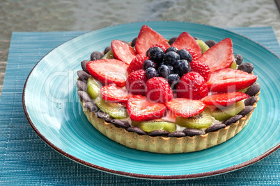 Large Fruit tart with mixed berries, including red strawberries