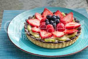 Large Fruit tart with mixed berries, including red strawberries