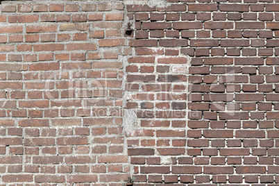 Facing bricks in a repaired wall in a dark red color in chain bo