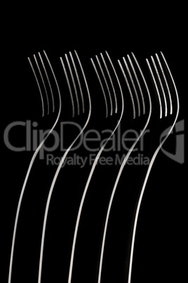Artistic place setting photo of five standing forks in a dark fi