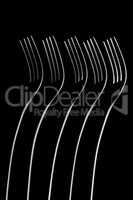Artistic place setting photo of five standing forks in a dark fi