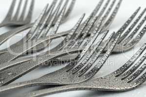 Artistic place setting photo of eight reclining forks with water