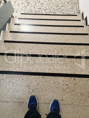 Legs on the background of the stairs going down
