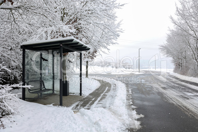 Bus stop by the snowy road in winter