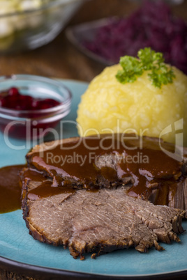 Sauerbraten mit Kartoffelknödel auf Holz