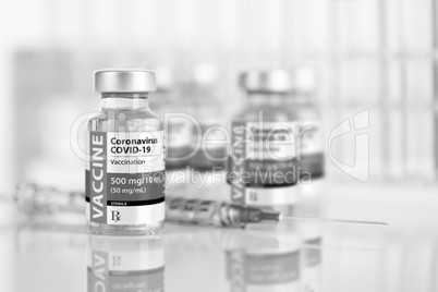 Coronavirus COVID-19 Vaccine Vials and Syringe On Reflective Sur