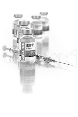 Coronavirus COVID-19 Vaccine Vials and Syringe On Reflective Sur