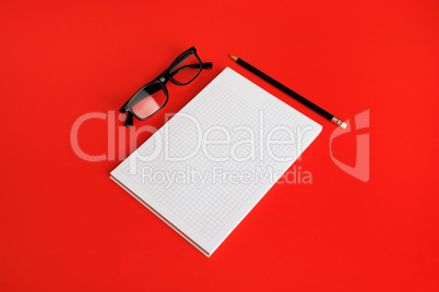 Blank copybook, glasses, pencil