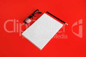 Blank copybook, glasses, pencil