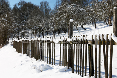 Wooden fence in the garden in winter