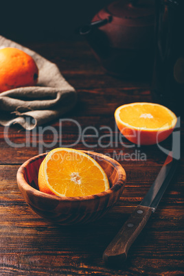 Half of orange in a wooden bowl