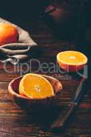 Half of orange in a wooden bowl