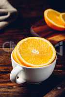 Sliced orange in a white cup