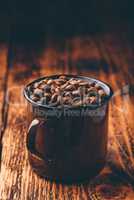 Mug full of roasted coffee beans