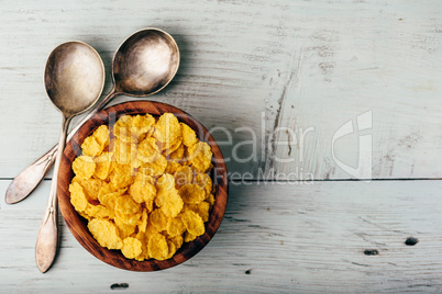 Rustic bowl of corn flakes with spoons