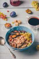 Porridge with plum, grapes and cup of coffee