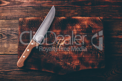 Knife over wooden cutting board