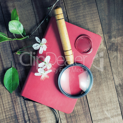 Notebook, magnifier, wax seal, flowers