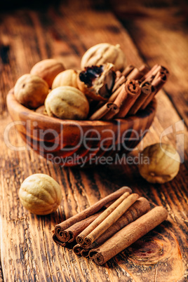 Cinnamon sticks and dried limes in wooden bowl