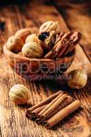 Cinnamon sticks and dried limes in wooden bowl