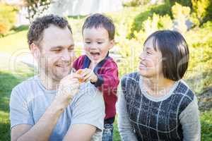 Happy Mixed Race Family Having Fun Outside on the Grass