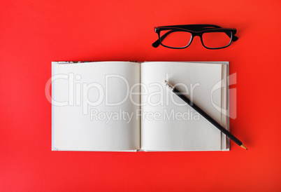 Blank brochure, pencil, glasses