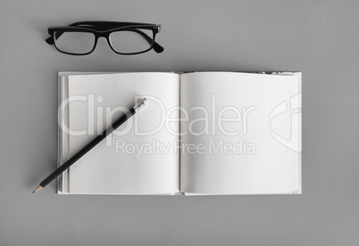 Blank book, pencil, glasses Blank book, pencil, glasses