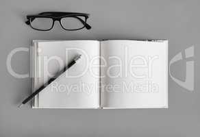 Blank book, pencil, glasses