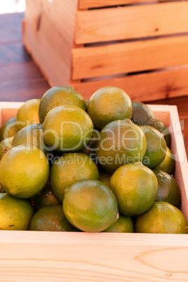 Green limes in a crate at a farmers market