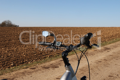 Bicycle steering wheel close-up on a plowed field
