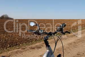 Bicycle steering wheel close-up on a plowed field